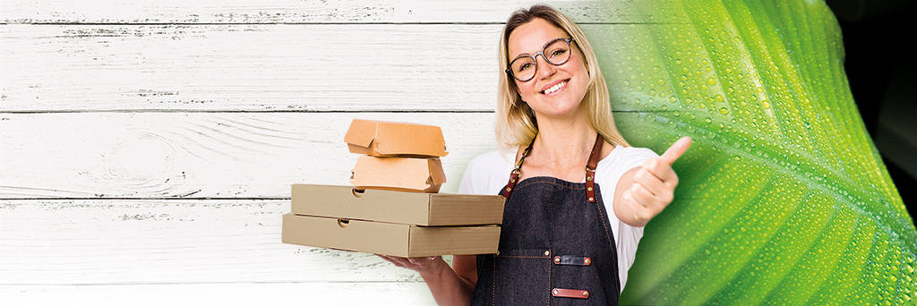 blonde junge Frau, lächelnd trägt Pizzakarton und Burgerschachtel und zeigt Daumen nach oben